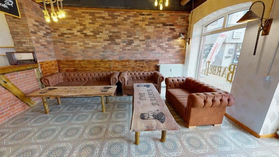 Lounge-Bereich mit Holztisch und The Barber Logo