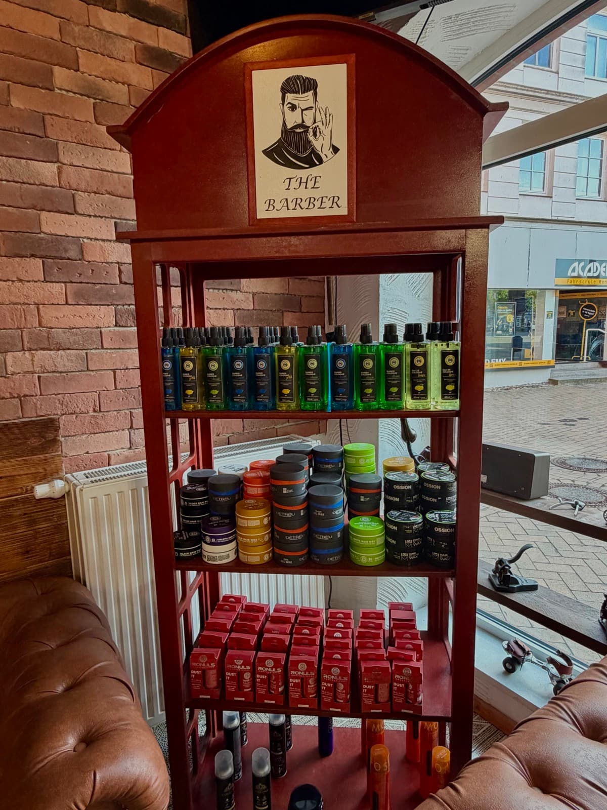 Pflegeprodukte im roten Produktschrank von The Barber Rendsburg